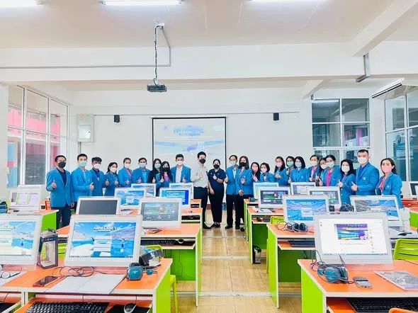 Charnsak Srisawatsakul stands with teachers in a computer lab during a Minecraft Education workshop