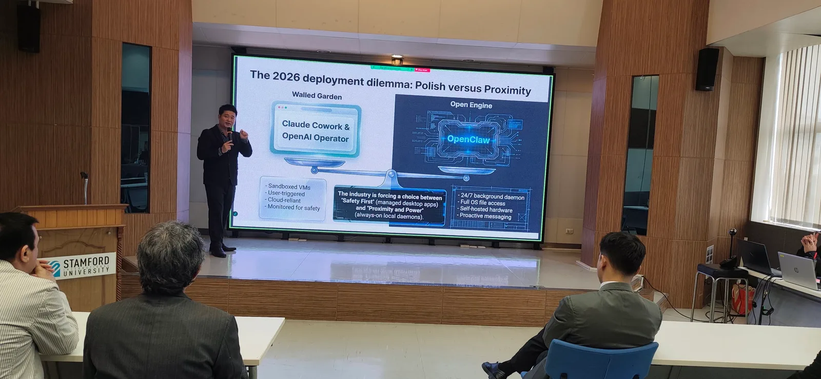 Charnsak Srisawatsakul presents an AI deployment slide to an audience in a university lecture hall